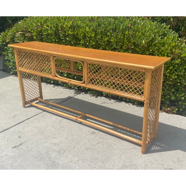This vintage rattan console table is a beautiful boho-chic addition to any entryway or living space, featuring trellis...