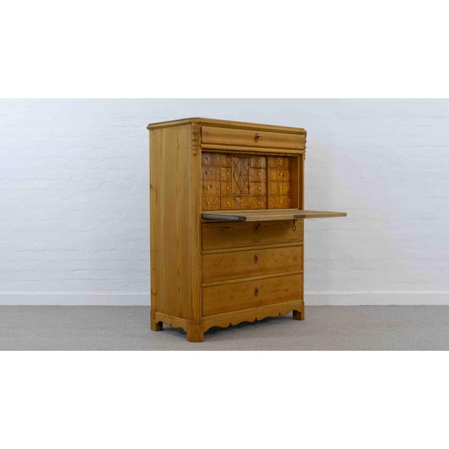 Late Biedermeier secretary desk, circa 1845-1860. Features four lockable drawers and a drop-front writing surface. Behind...