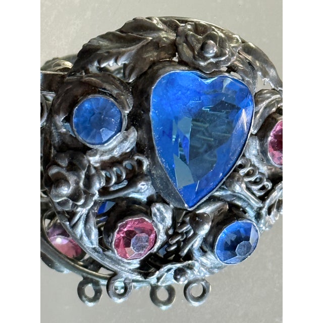 This 1940s Hobé sterling silver brooch features the intricate floral detailing and jewel-like construction associated with...