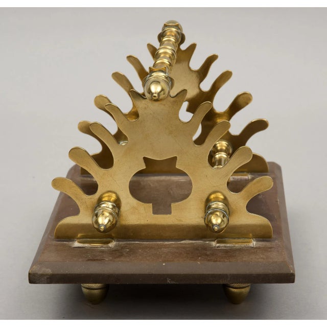 Very unusual brass and gutta percha pen stand with acorn-shaped finials and feet. There are slots for eight pens. Gutta...