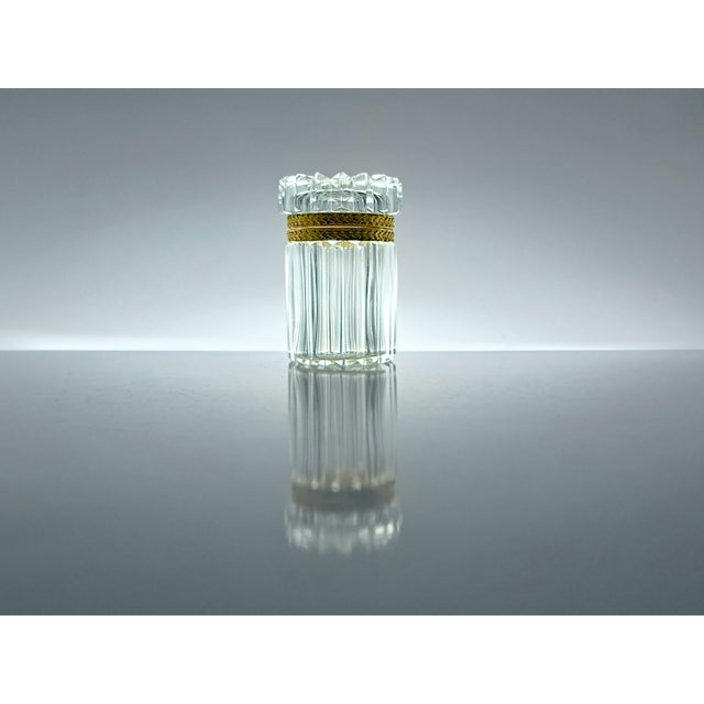 Refined cylindrical case in solid cut crystal and gilded metal, inspired by the elegance of historic Baccarat crystalworks...