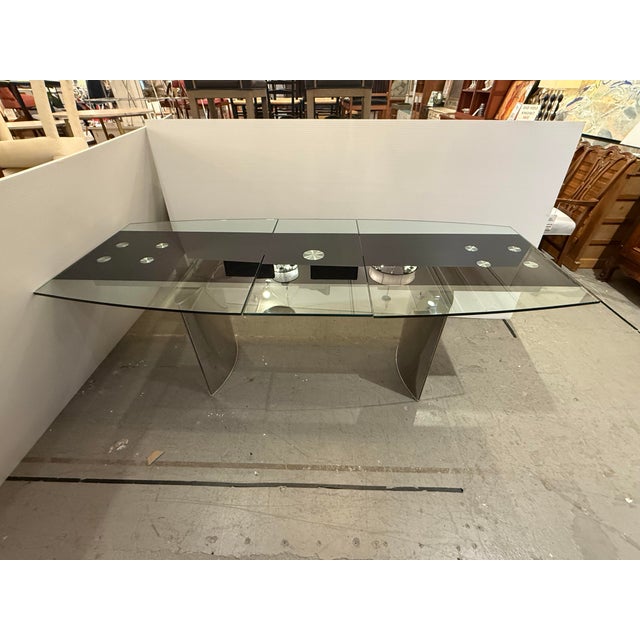 Design Plus Gallery presents a Modern Extendable Glass Top Table. The sculptural top has a bowed outline with a two-panel...