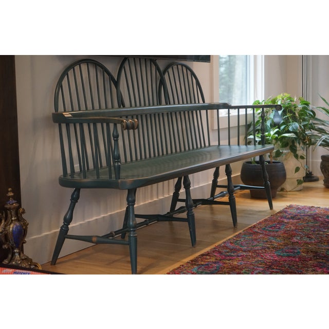 Classic Windsor-style bench featuring a curved spindle back and elegantly turned legs. Finished in a deep green tone with...