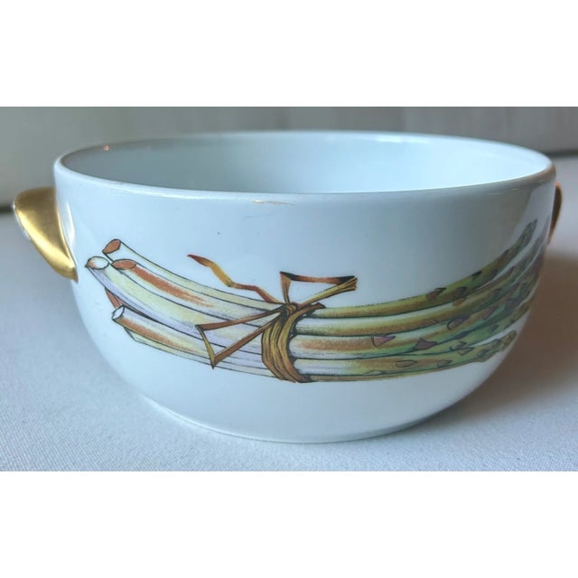 Made in England, this Royal Worcester “Evesham” white porcelain serving bowl with gold handles has detailed artwork...