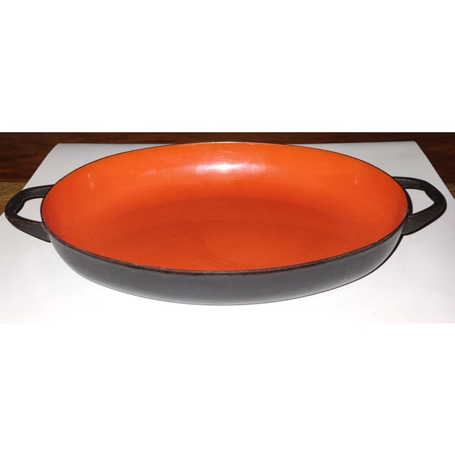 This orangey-red, oval enamelware piece is in great vintage condition. It can be cooked in - on the stovetop or in the...