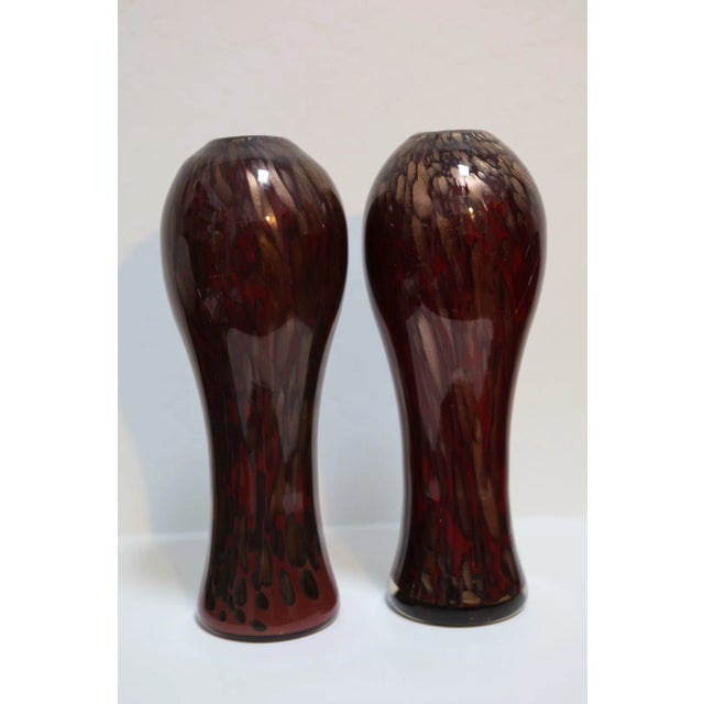Beautiful, large matched pair of mid-century Murano glass vases. Expertly crafted in shades of crimson with avventurina...