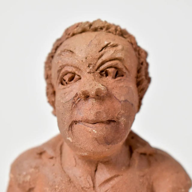 A female figure with a fish hand modeled with earthenware terracotta clay from Malawi. Fired naturally with a raku...
