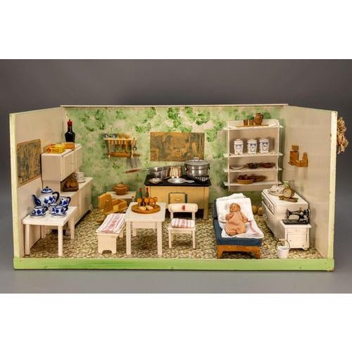 German Folk Art dollhouse kitchen scene, circa 1930s–1940s. Charming miniature interior set within a wooden display,...
