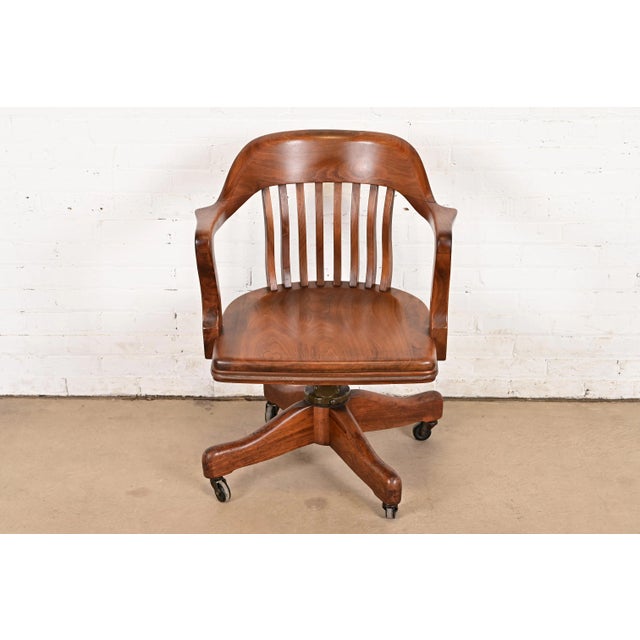 An exceptional Arts & Crafts, Mission, or Mid-Century Modern carved solid walnut executive swivel desk chair By Johnson...