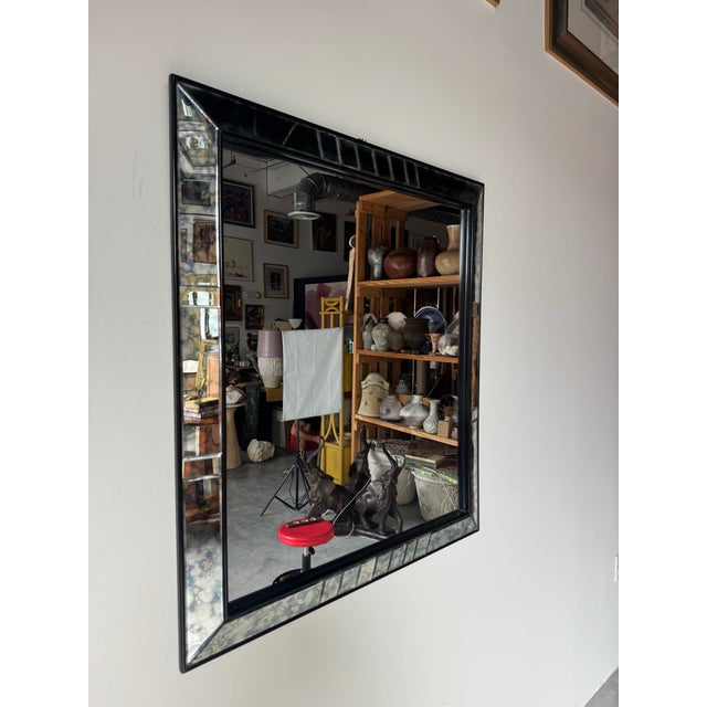 Striking original 1960s Hollywood Regency wall mirror featuring a bold black lacquered frame accented with distressed...