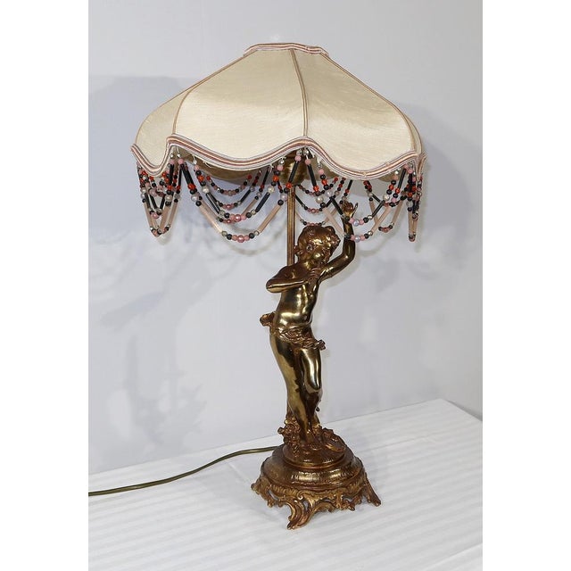 Charming lamp in Boronée patina regulating representing a young dancing musician, summoned with a lampshade with the...
