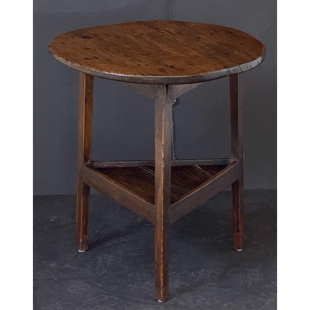 A handsome English cricket table of patinated oak from the Georgian Era, featuring the traditional round or circular top...
