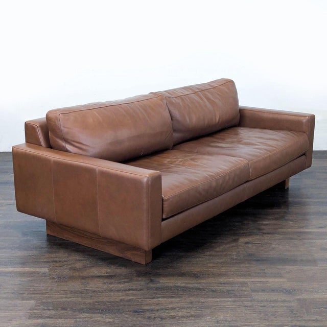 This Room & Board 3-seat sofa features genuine brown leather and a sturdy, modern frame. The wide armrests and thick...