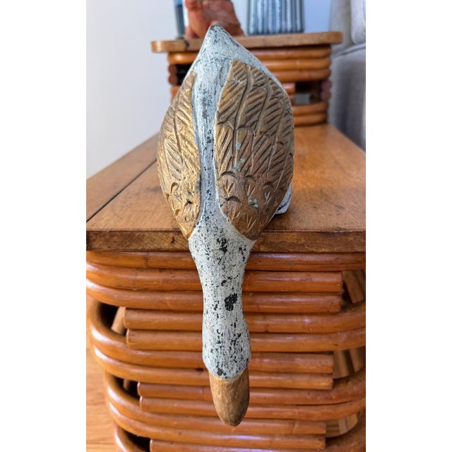 Diving down duck figure sits on a shelf or table top edge. Rustic and wooden with teal and gold coloring. Cute addition to...