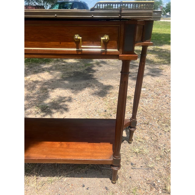 Elegant 19th-century French Louis XVI console table crafted in richly grained mahogany with refined neoclassical styling....