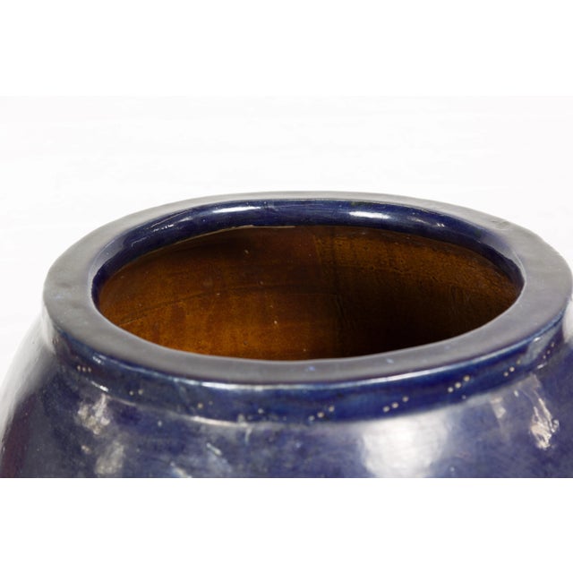 An oversized vintage Thai water vessel from the mid-20th century, with midnight blue glaze, and tapering lines. Created in...