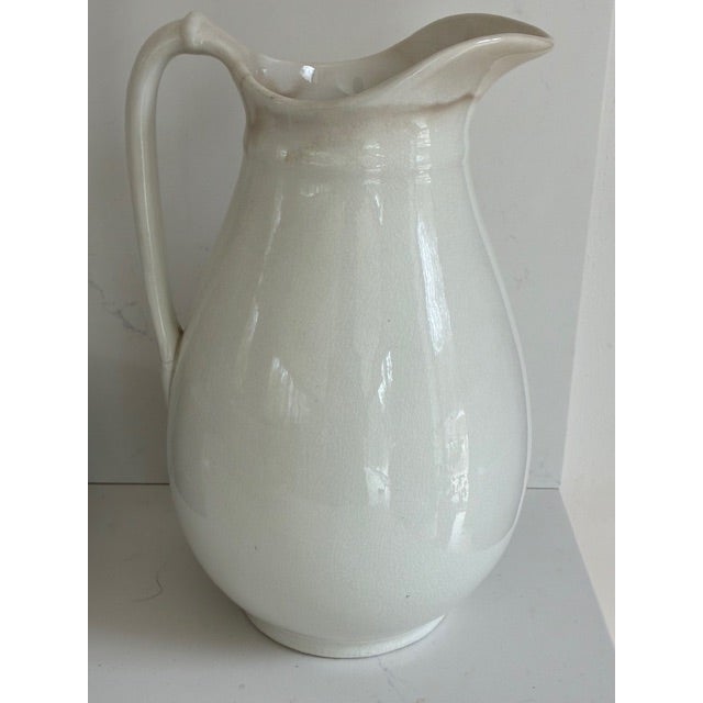 Tall, good form, ironstone pitcher. There is slight crazing and discoloration, in good useable condition.