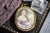 This remarkable oversized portrait miniature, dated 1912 and artist-signed, captures the refined elegance of the Gilded...