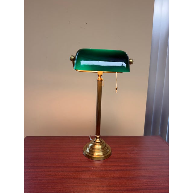 This classic banker’s lamp is crafted from solid brass and features a traditional green Vianne glass shade. The lamp is...