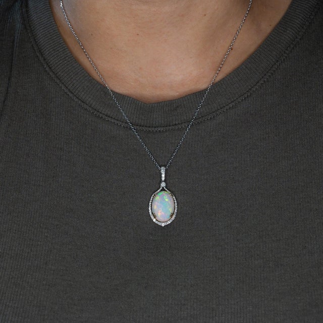 A large 8.41-carat Ethiopian opal cabochon flashes with a full play of color across this solid two-tone 14K white and...