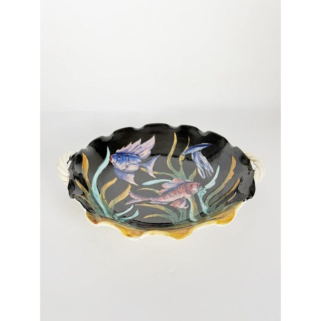 Striking French ceramic dish featuring a hand-painted underwater scene with colorful fish swimming among aquatic plants...