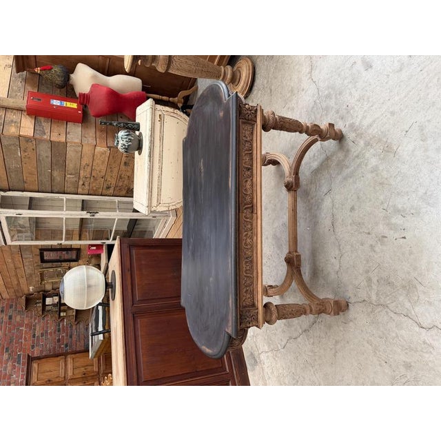 This antique oak console table has been fully restored. It features a black-patinated top, a trim, and a base made of...