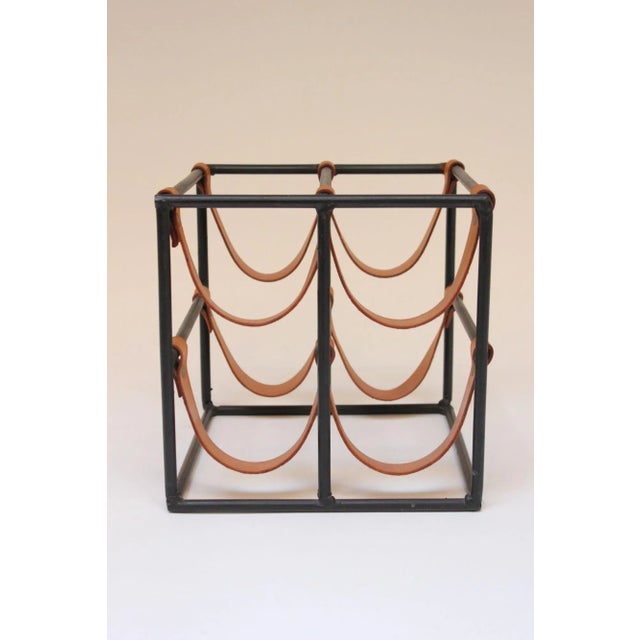 Mid-Century American Modern wine rack by Arthur Umanoff for Shaver Howard composed of eight saddle-leather strap holders...