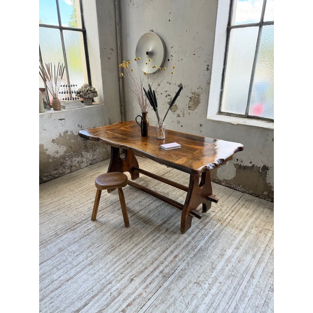 A truly unique, handcrafted vintage dining table made of solid olive wood by maison skela in the 1960s. A french...