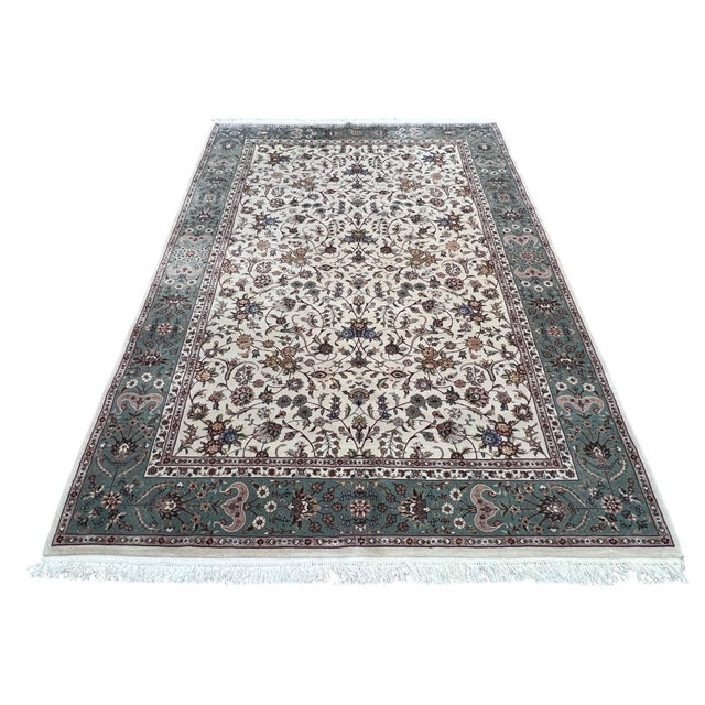 Indo Persian Tabriz rug, hand knotted in India from 100% wool with silk highlights. Measuring 6’1” x 9’, the rug features...
