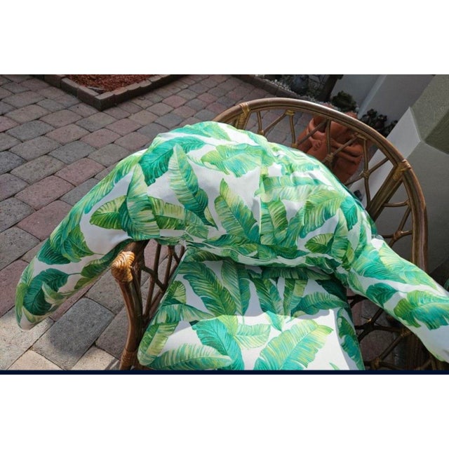 Splendid pair of vintage bamboo club chairs with custom upholstery in banana leaves pattern.