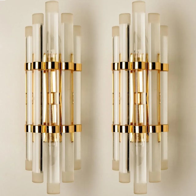 Pair of Murano wall sconces. Each wall sconce is featuring five crystal clear glass semi circles, with brass details and...