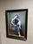 The artwork presents a figure seated in an elegant chair, draped in a flowing garment that softly contrasts with the muted...