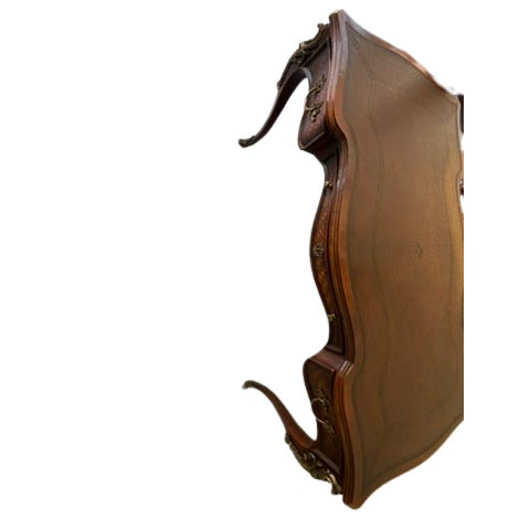 Bureau plat writing desk with intricate details and a classic design. Features a leather top and detailed carvings on the...