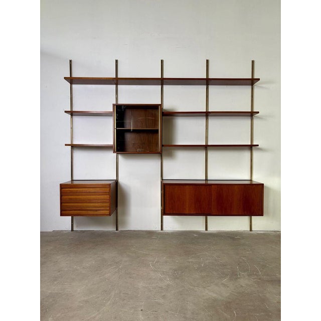 Iron and wood wall bookcase by Osvaldo Borsani E22 production Tecno 1960s Modular wall-mounted bookcase made of wood and...
