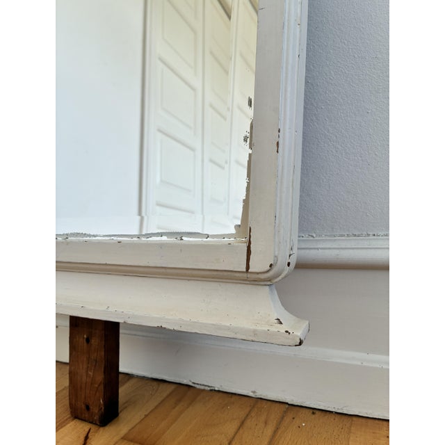 An antique European full-length floor mirror, dating to the early 20th century. The mirror glass has a beveled edge and is...