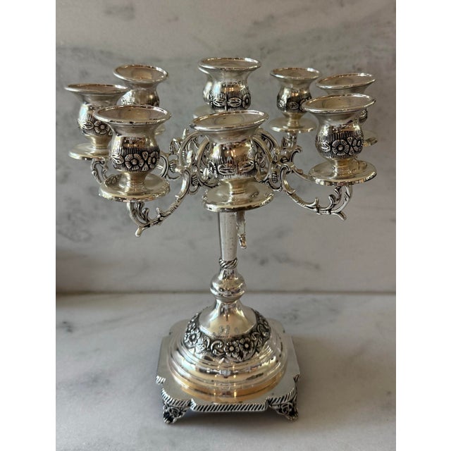 Vintage silver plate candelabra with 8 arms and a central ninth holder featuring an ornate square stepped base and floral...