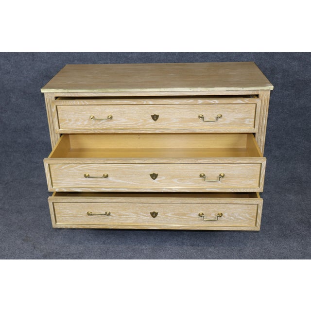An exceptionally elegant pair of English-made commodes in the French Louis XVI style, beautifully crafted in cerused oak...