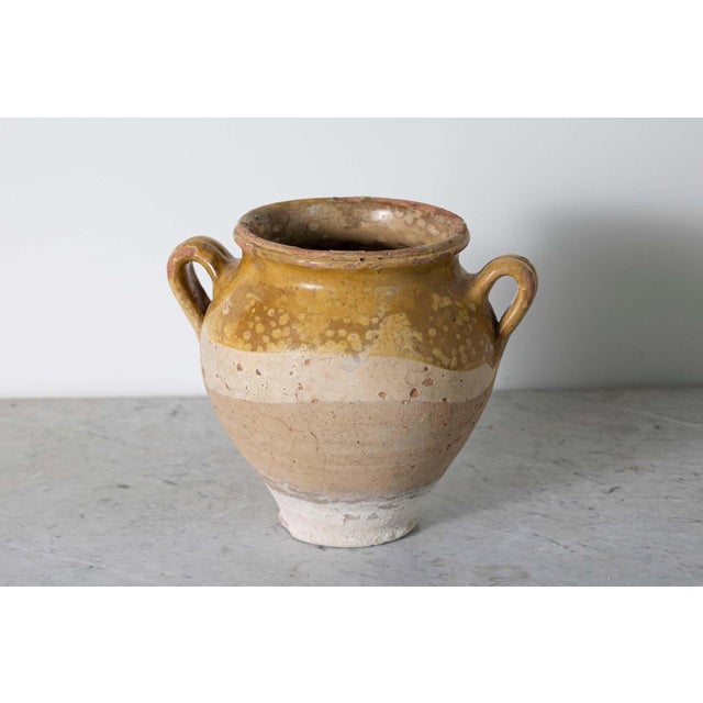 This 19th-century Spanish terracotta glazed pottery jar, exemplifies rustic elegance and traditional craftsmanship....