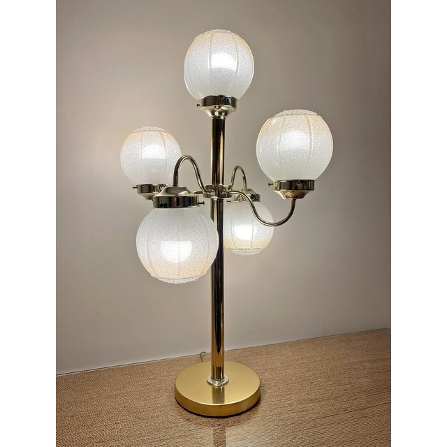 A striking vintage five-globe sculptural table lamp featuring a polished brass frame and five original textured frosted...
