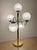 A striking vintage five-globe sculptural table lamp featuring a polished brass frame and five original textured frosted...