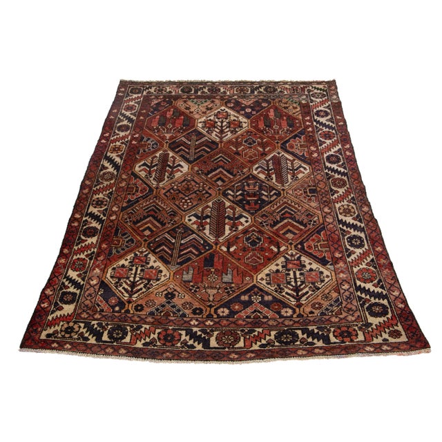 This Vintage Persian Bakhtiari Persian wool rug has a rust color field and accents in red, beige, and navy blue. This rug...