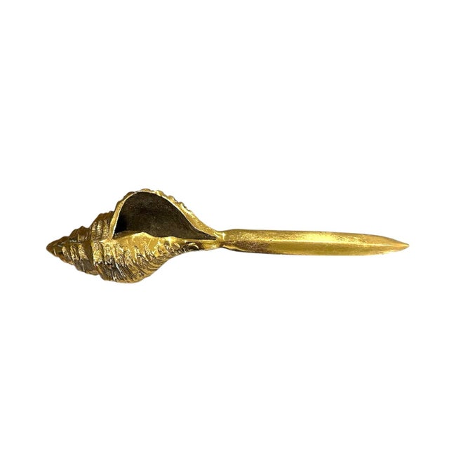 A vintage, brass letter opener. Features a solid, cast brass letter opener in the form of a conch shell. Unmarked. Circa...