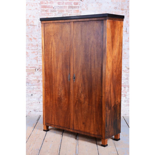 This authentic Biedermeier two-door wardrobe originates from Bohemia from the early 19th century. Its carcass is crafted...