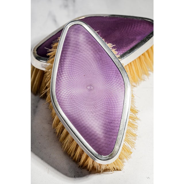 A wonderful example of early 20th-century English vanity accessories, this matched pair of antique sterling silver-backed...