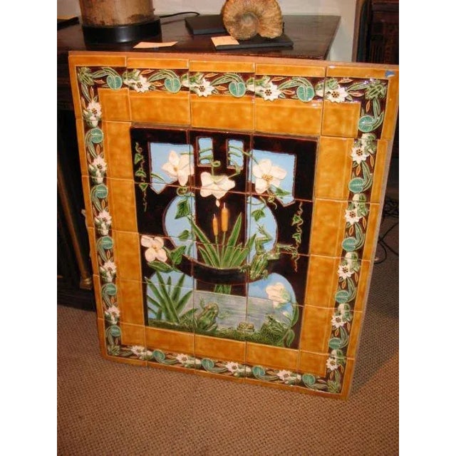 A nice large and bright majolica pottery tile panel depicting jumping frogs in a pond with cattails and flowering vines....