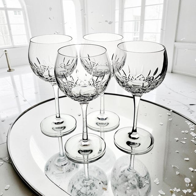 Set of four Waterford Crystal Lismore Essence balloon wine glasses produced in Ireland. The glasses feature the Lismore...