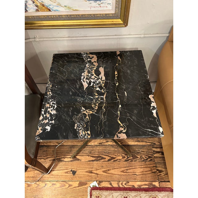 Stunning pair of French deco marble top end tables having rich black marble tops with camel and cream grain, with elegant...