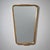 Trapezoidal wall mirror in a molded giltwood frame with shaped accents along the sides. The gilding shows areas of age-...