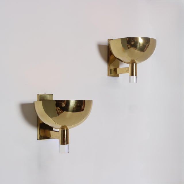 Pair of large scale brass and lucite sconces. Half globe in brass with a perforated brass grill diffuser over bulb,...
