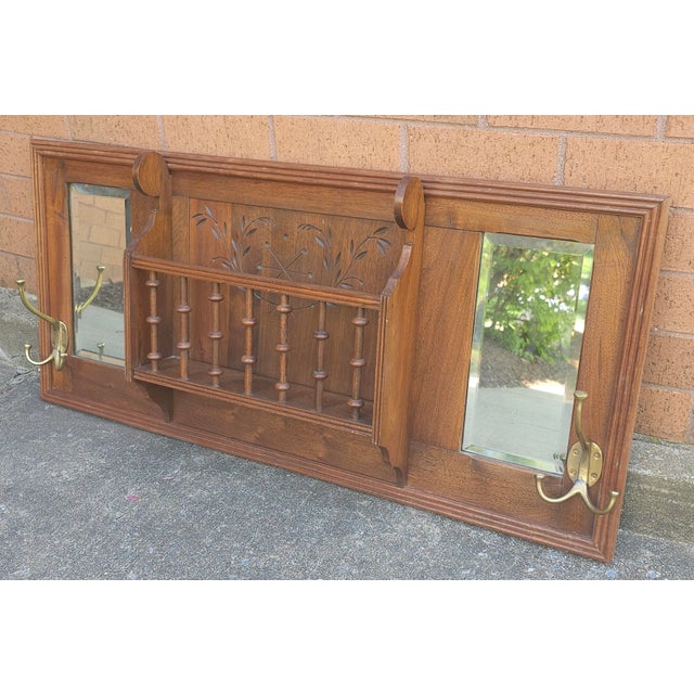 A Mid-20th Century Walnut Double bevel Mirrored Coat and Hat Rack with a Spindle Storage Slot. Measures 39" in width and...